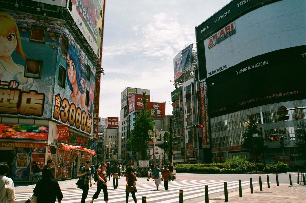 Bustling urban street in Shinjuku, Tokyo showcasing Japanese culture and vibrant billboards.