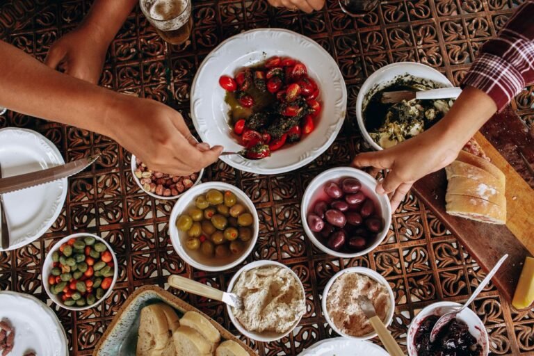 An appetizing spread of Mediterranean dishes enjoyed by friends at a vibrant communal table.
